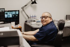 A man smiling at his office