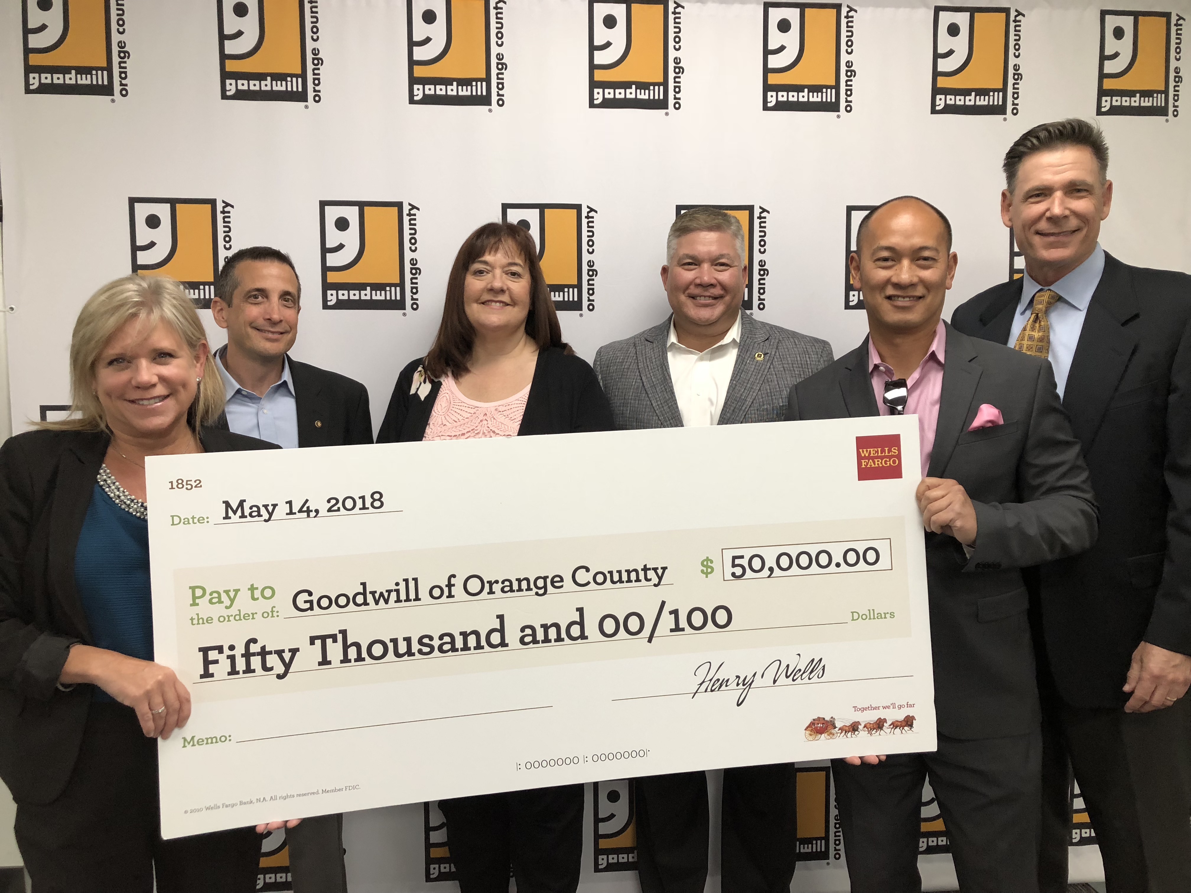 Goodwill representatives holding a $50,000 grant from Wells Fargo