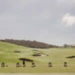 Man hitting golf balls at Pelican Hill golf course driving range.
