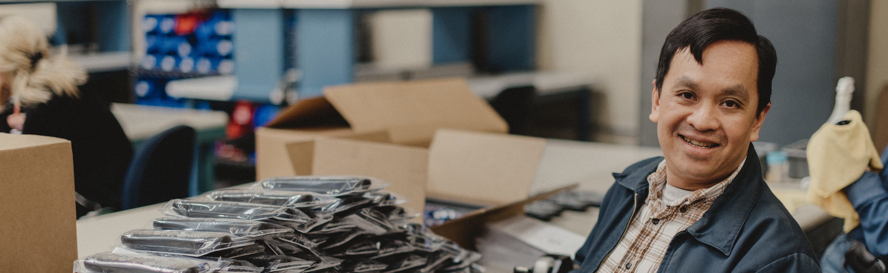 Goodwill of Orange County employee packaging a pile of television remotes