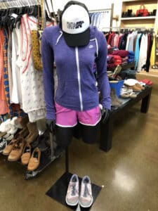 Mannequin with purple jackets and pink short displayed inside Goodwill Store & Donation Center