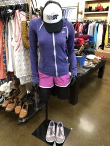 Mannequin with purple jackets and pink short displayed inside Goodwill Store & Donation Center