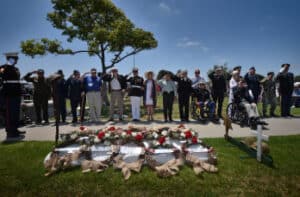 People saluting honoring military personnel who died in the service of their country