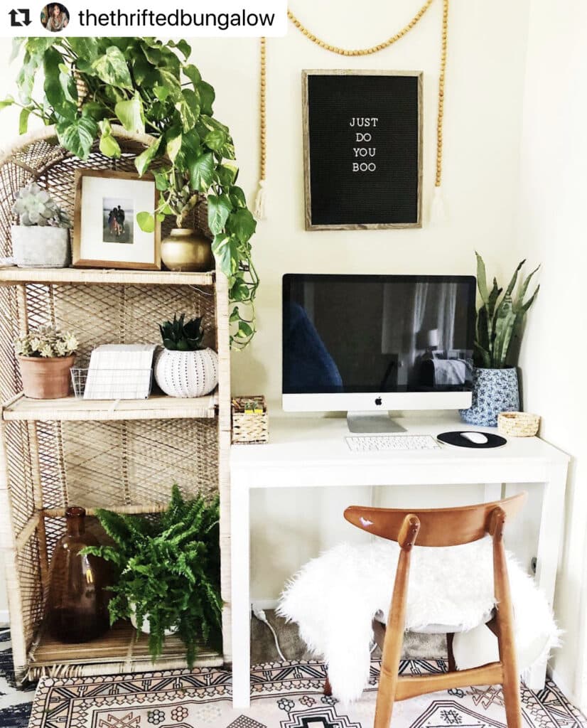 Well arranged work space with a MAC on a table, plants, and a chair