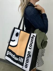 A women with Goodwill of Orange County reusable bag on her shoulder