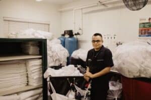 A man in front of linen bedding sheets closet