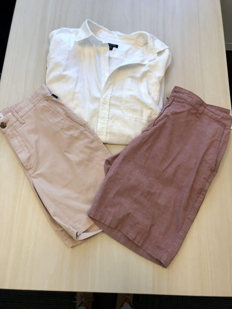 White button down with muted red or pink shorts
