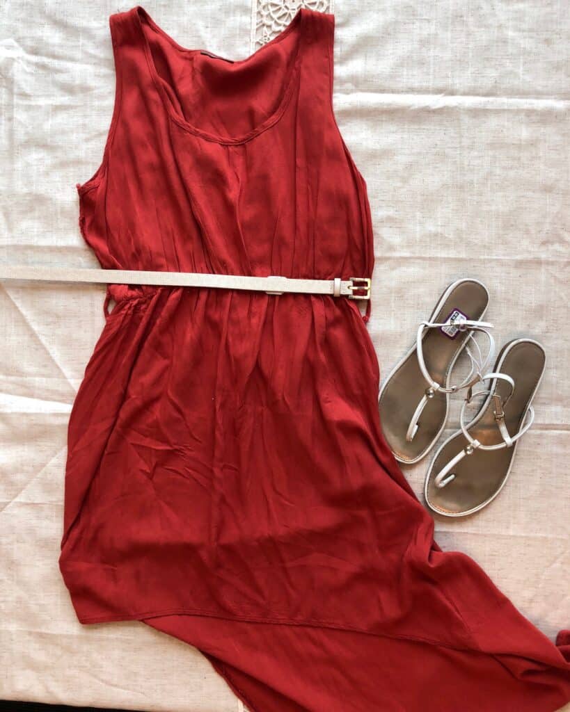 A sleeveless red dress with neutral belt and strappy sandals