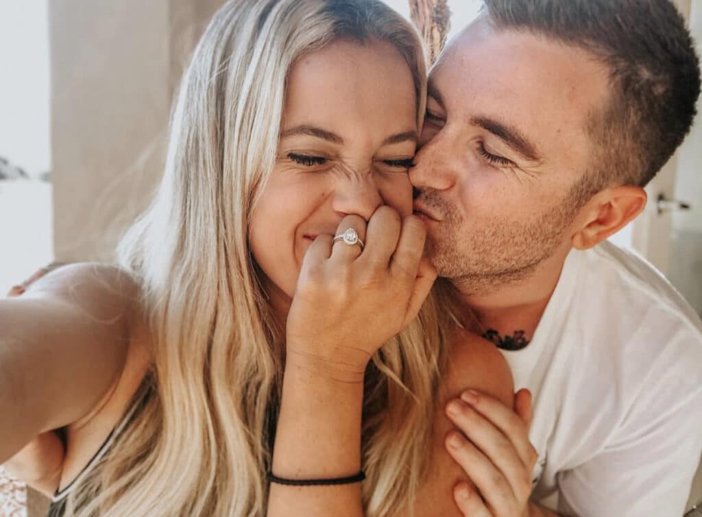 Natalie smiling as her boyfriend Grady plants a kiss on her cheeks