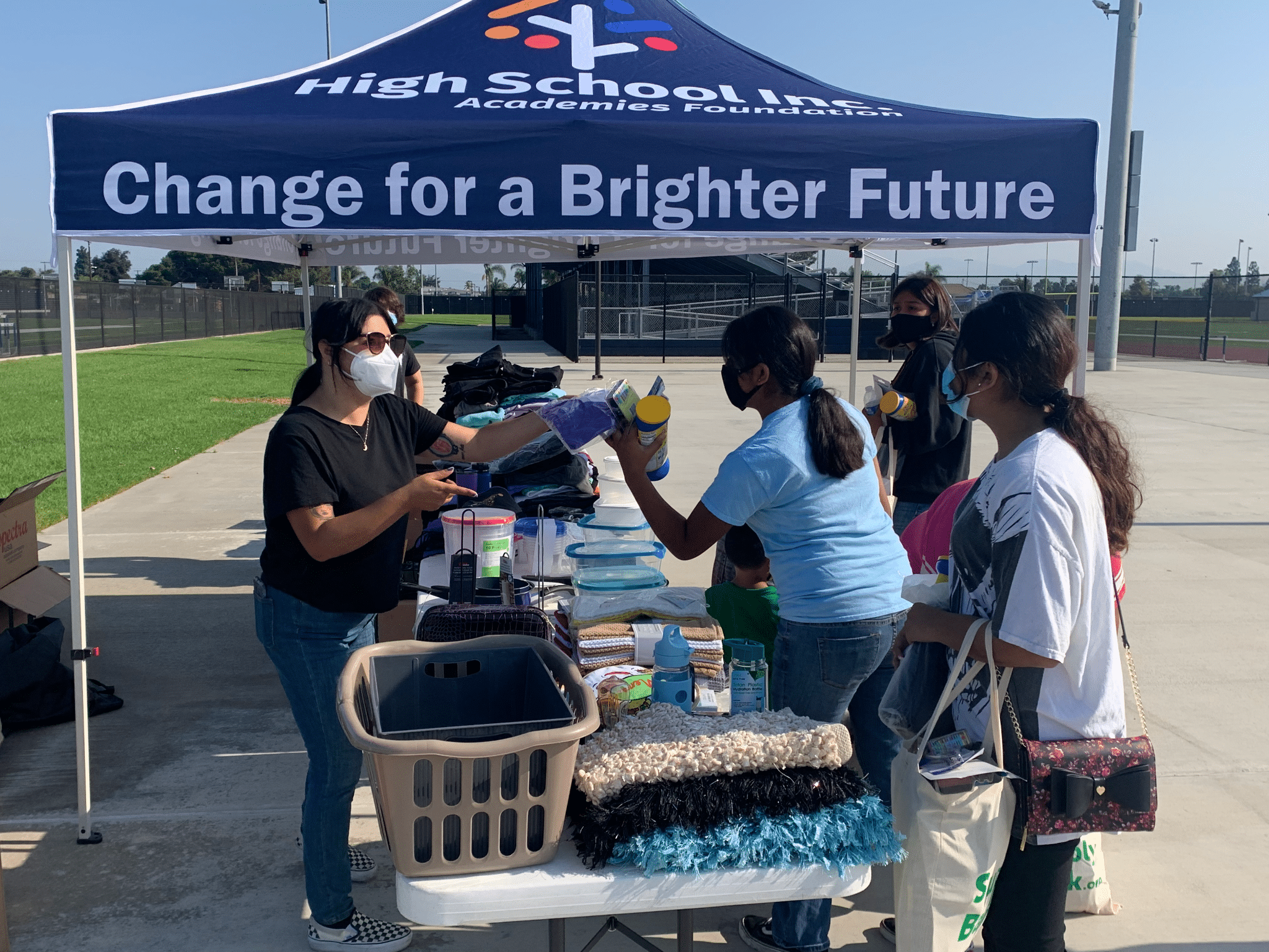 A lady distributing learning kits to students