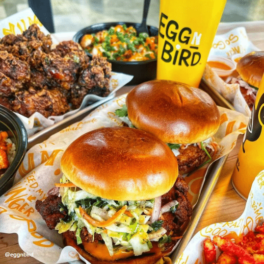 food table with chicken burger and side dishes