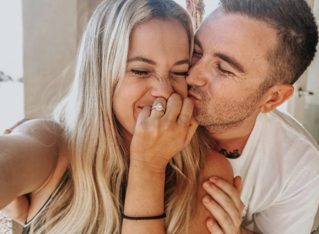 Natalie smiling as her boyfriend Grady plants a kiss on her cheeks