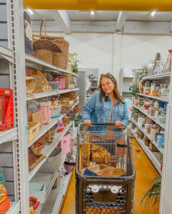 A girl in blue jacket and shopping cart