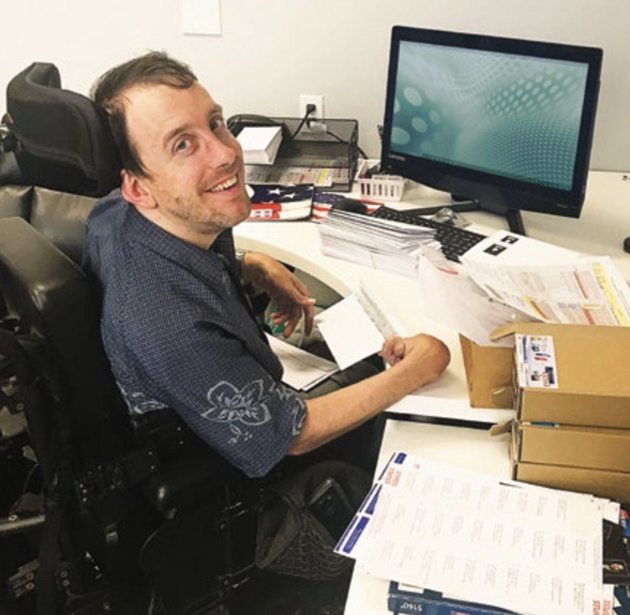 A man smiling at his office